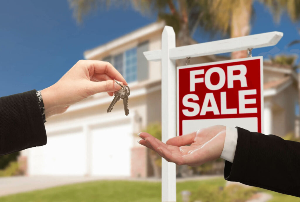 Keys exchanged beside for sale sign